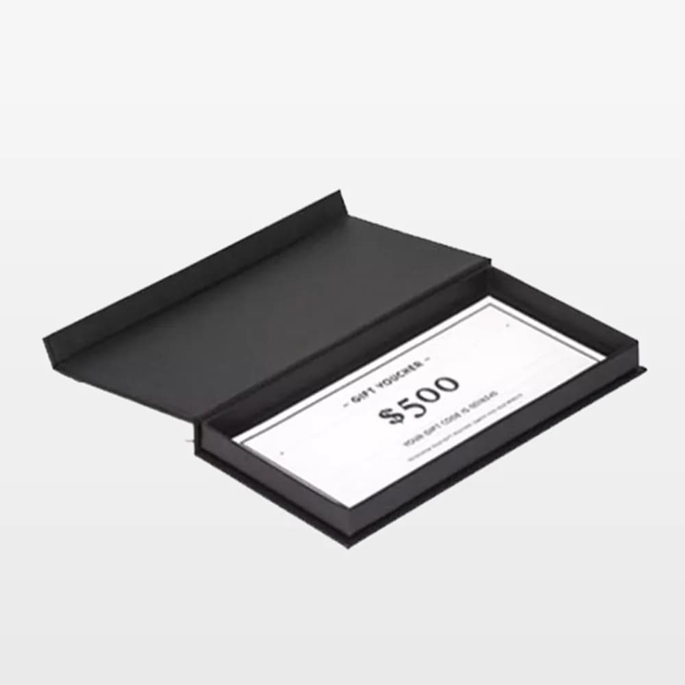جعبه کتابی مشکی کم‌ارتفاع و باز با یک وچر هدیه سفید داخل آن